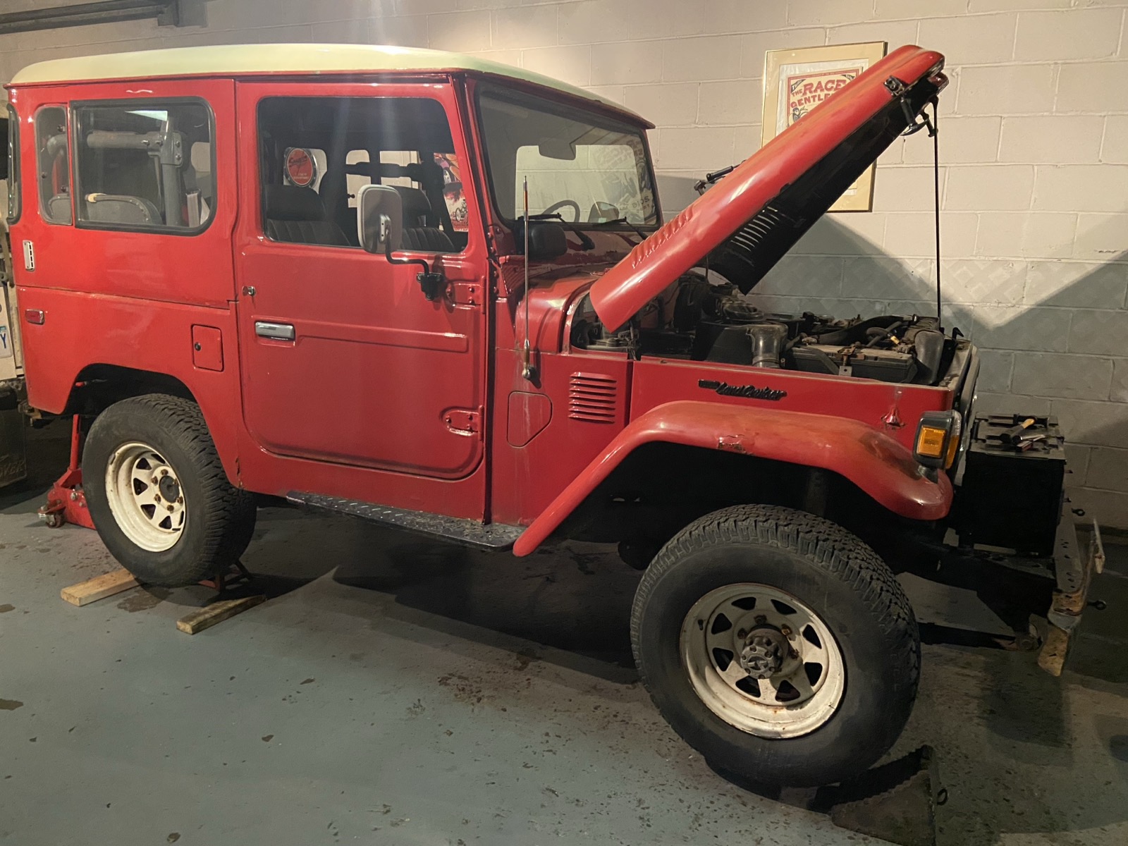 Red 1981 Toyota Land Cruiser BJ40 in a workshop with the hood up