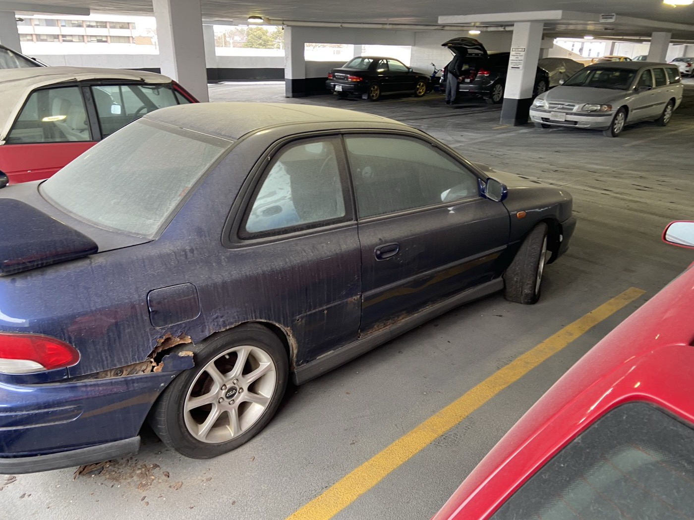 Rusted rear quarter of the blue GC8 parts car