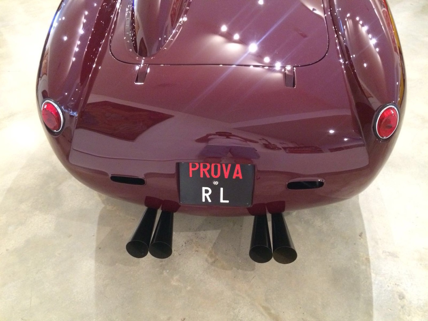Rear of the maroon Ferrari 250 Testa Rossa with PROVA plate and four exhaust tips