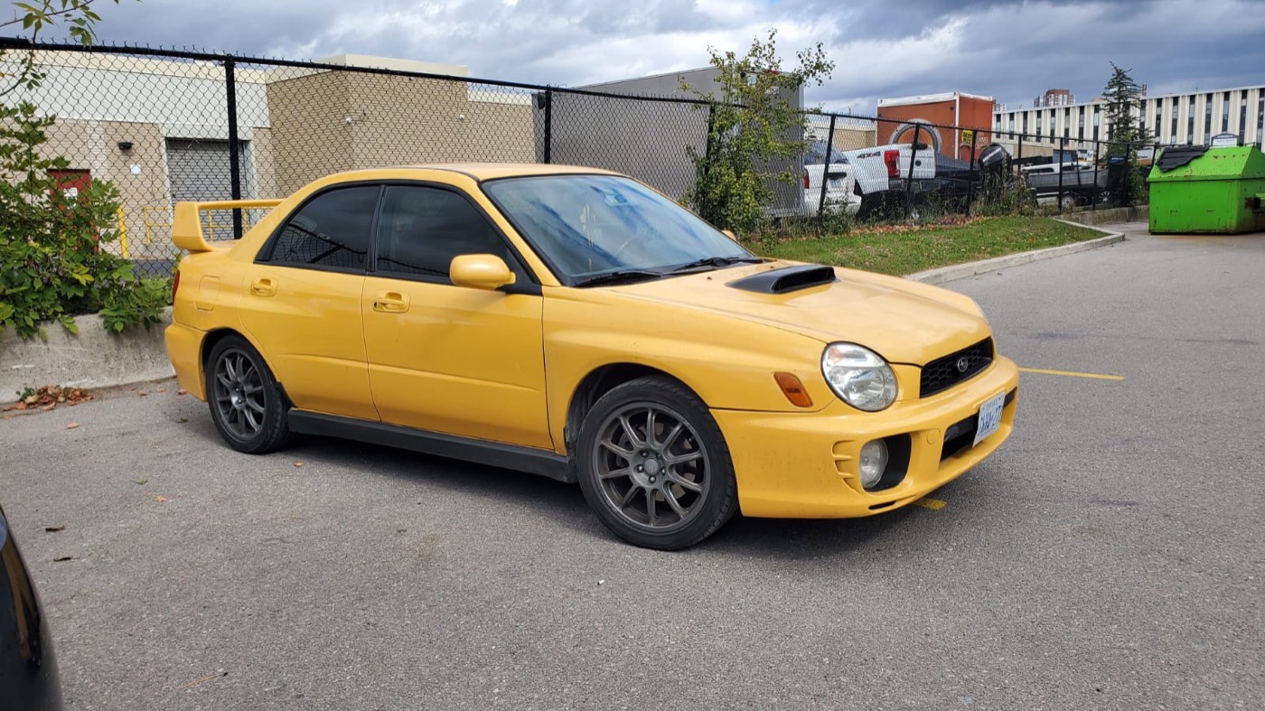 Sonic Yellow 2003 Subaru WRX sedan, front three-quarter, in a parking lot
