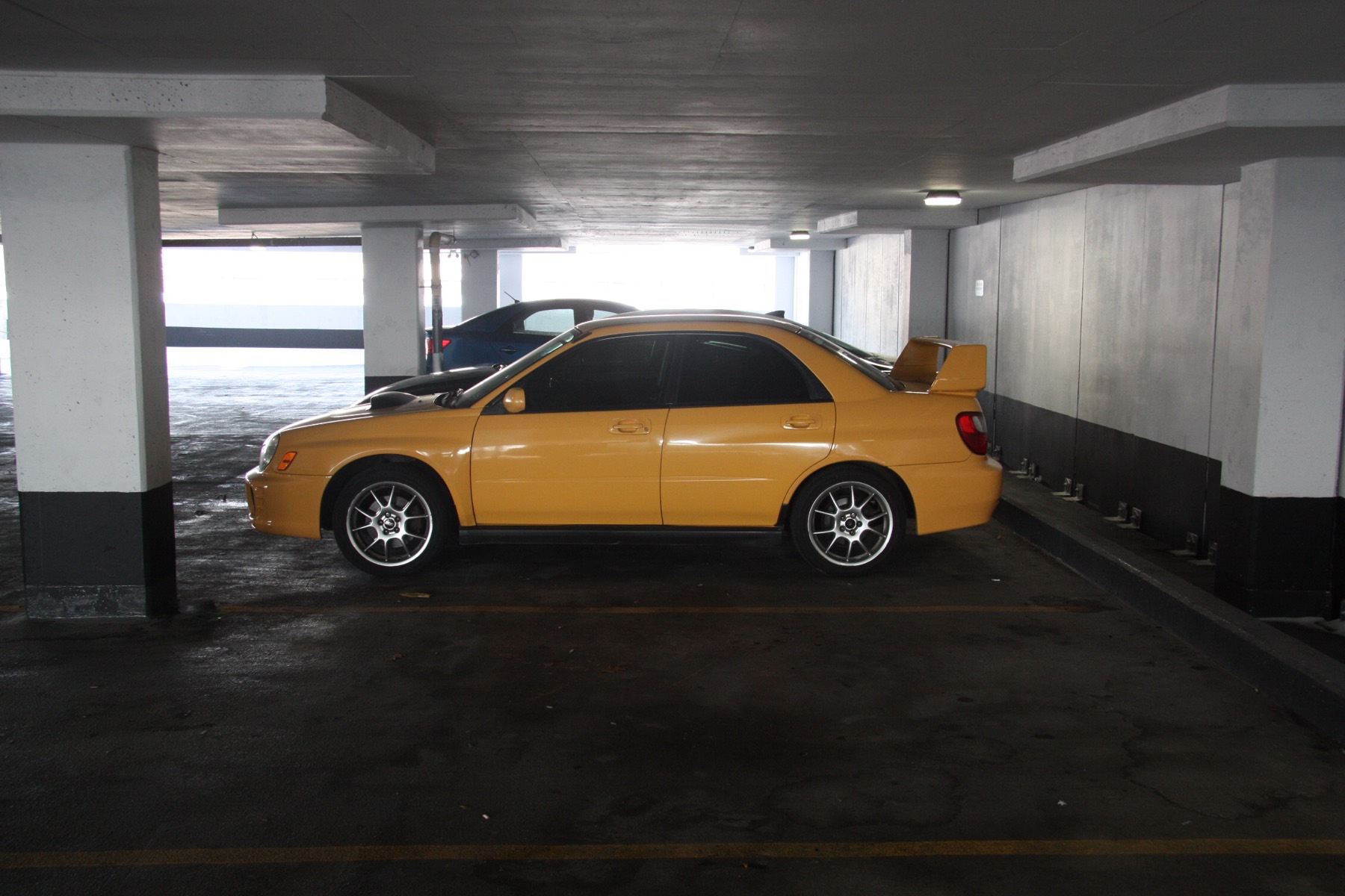 Sonic Yellow 2003 Subaru WRX parked in an underground garage