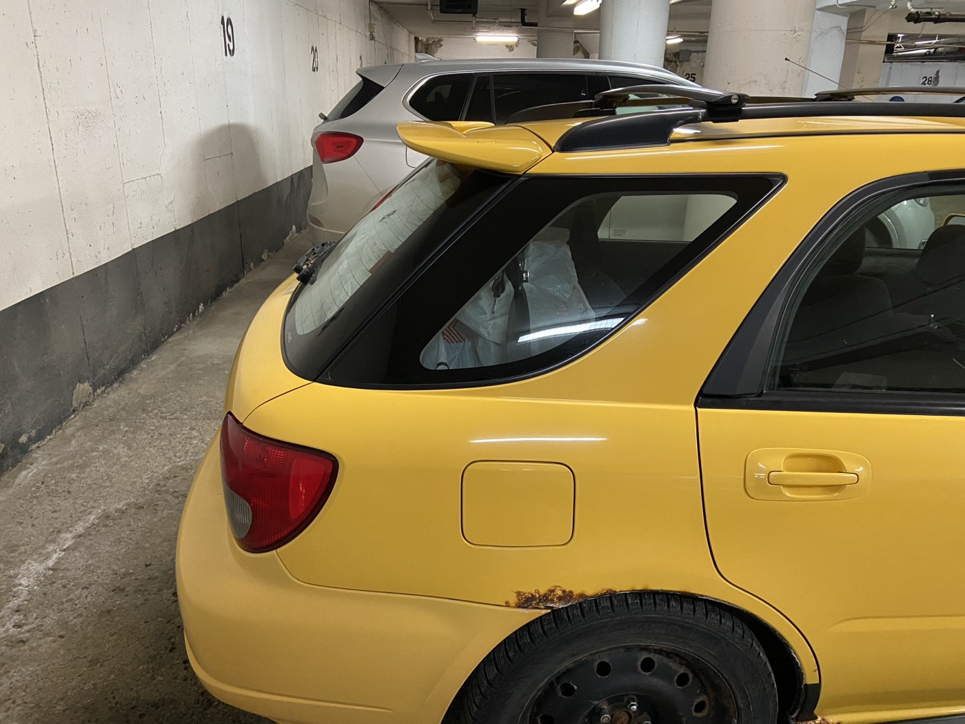 Sonic Yellow WRX wagon, rear three-quarter, in an underground garage