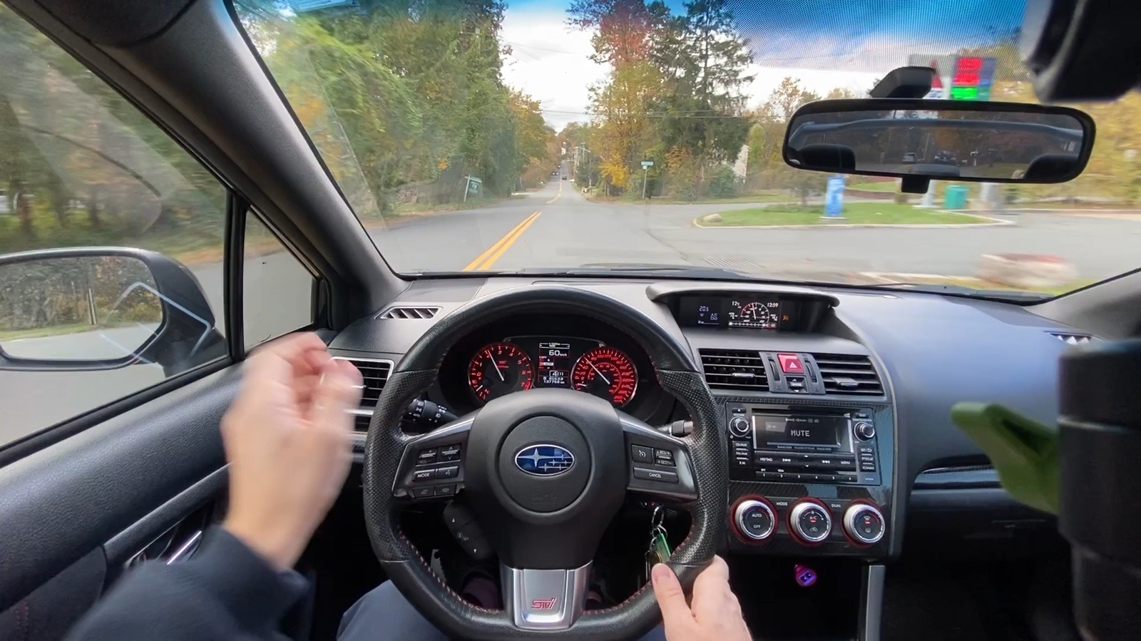 Driver's view from the 2015 Subaru WRX STI on a tree-lined road in fall